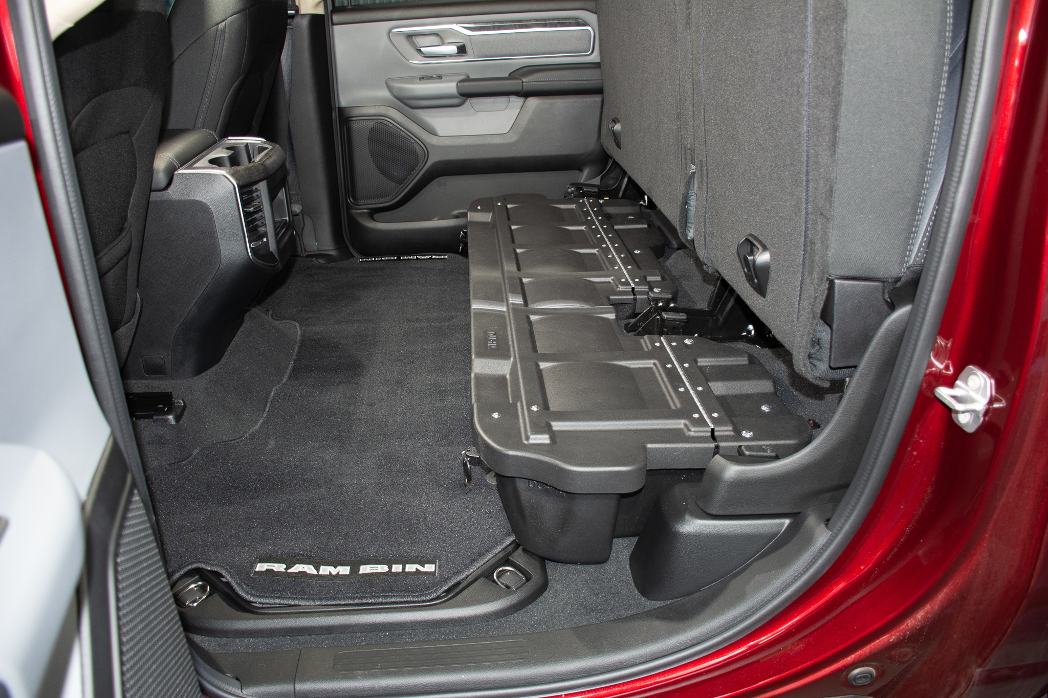 The DU-HA fits underneath the pre-existing back seats of your truck. The DU-HA will hold larger items without the organizers / gun rack installed.