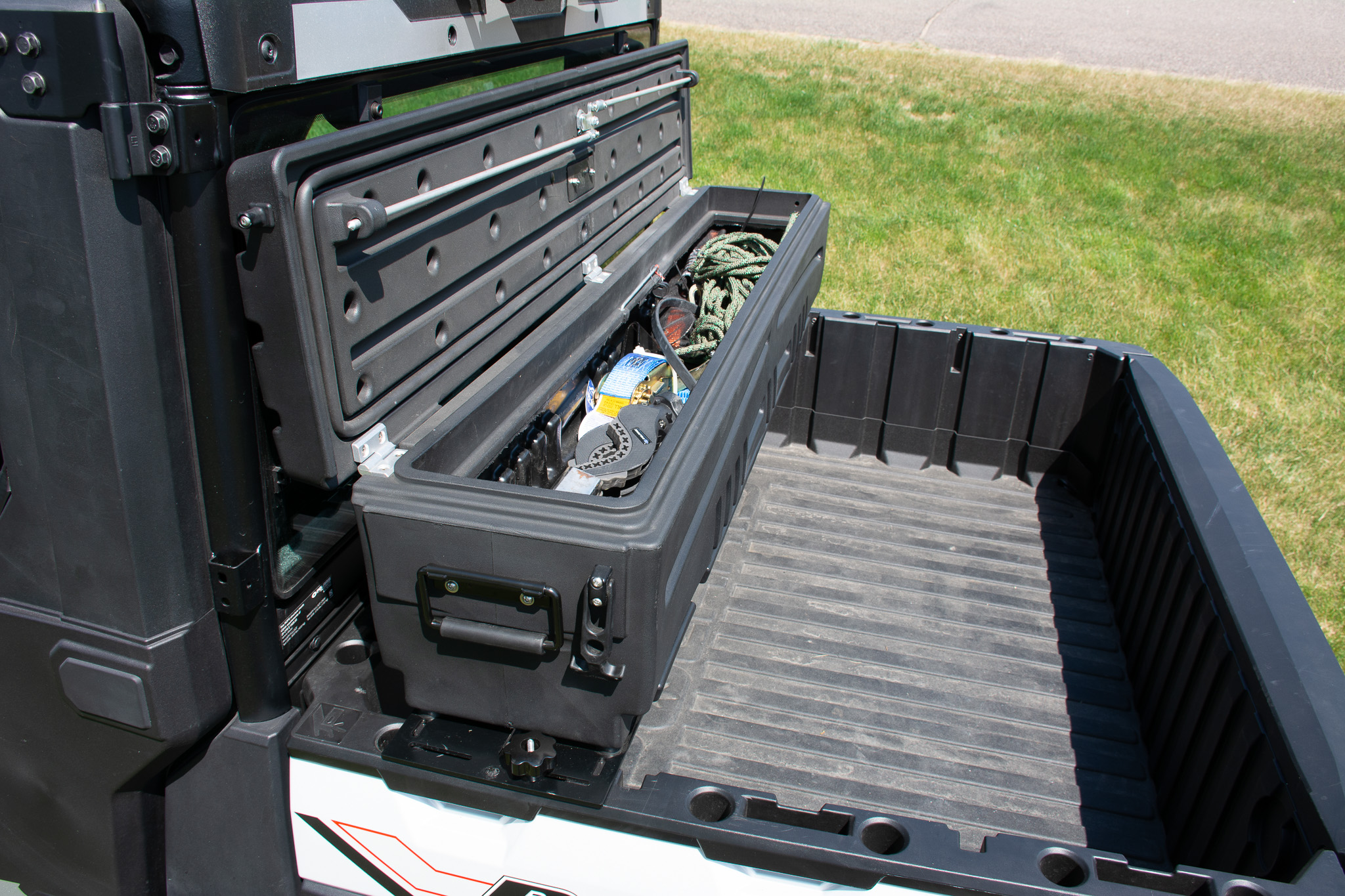 ATV storage box mounted atop ATV/UTV bed to store and protect gear, tools, and firearms.